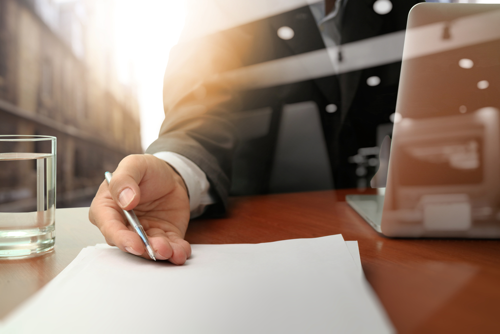 man-holding -a-pen-on-a-paper