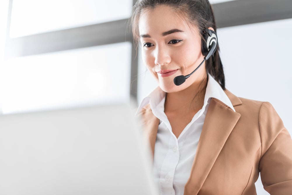 smiling woman with headset and laptop