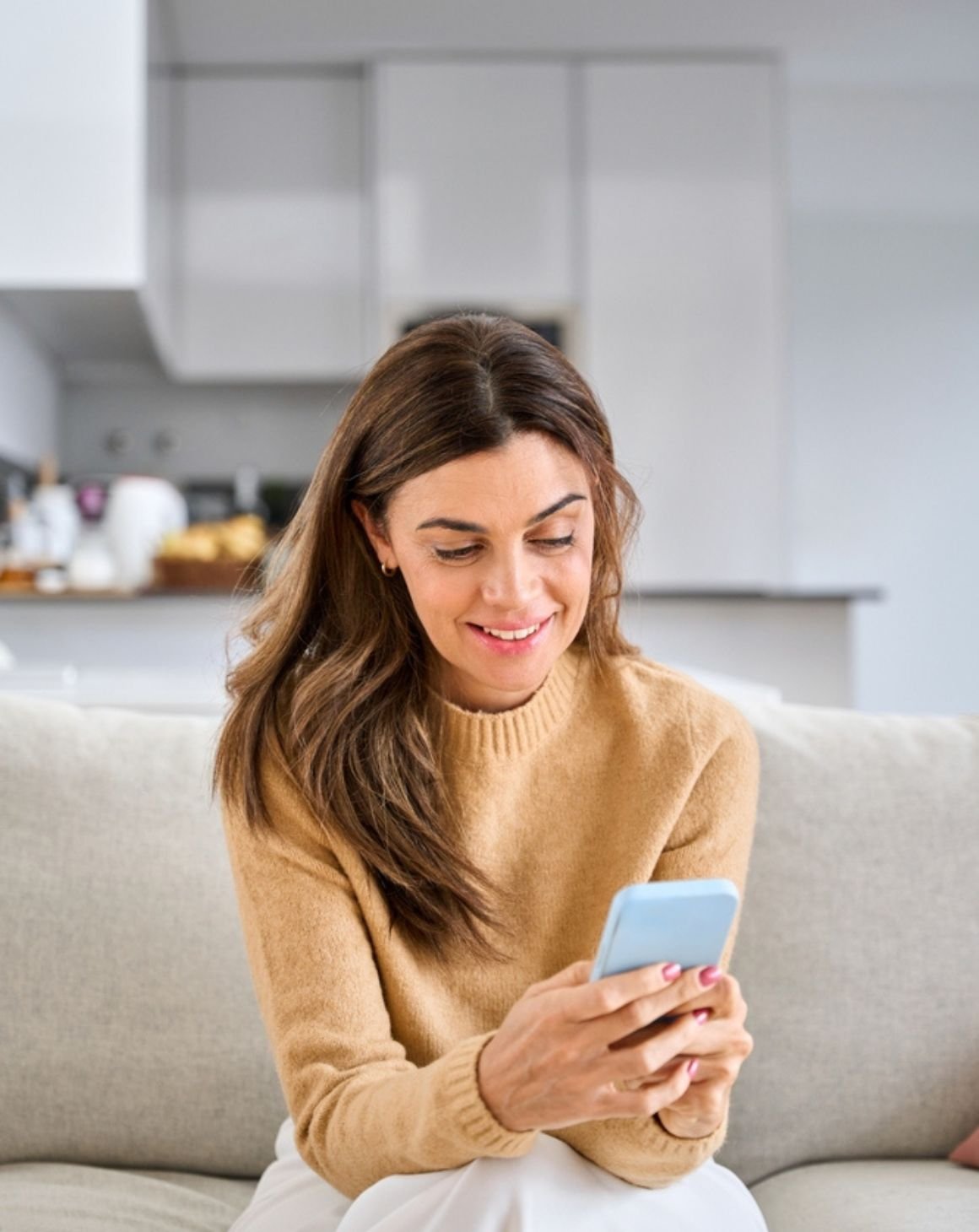 woman comfortably sitting on couch shopping on phone