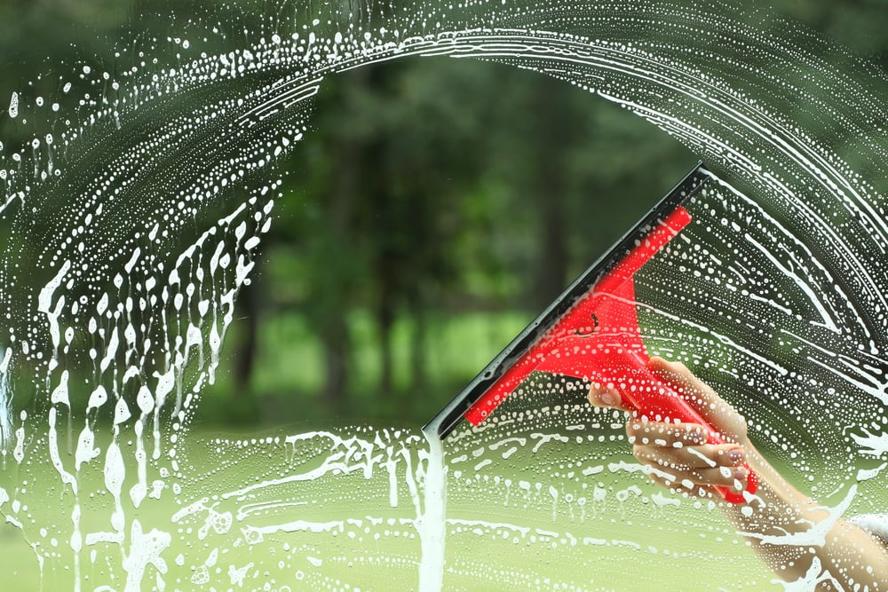 window getting cleaned with squeegee
