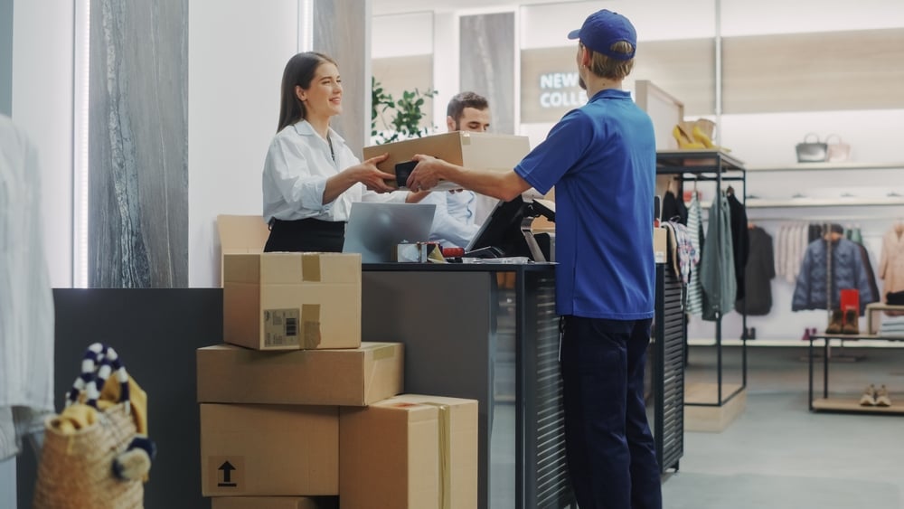 woman handing over package at shipping carrier counter